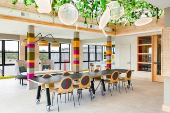 A large dining room with a long table and chairs